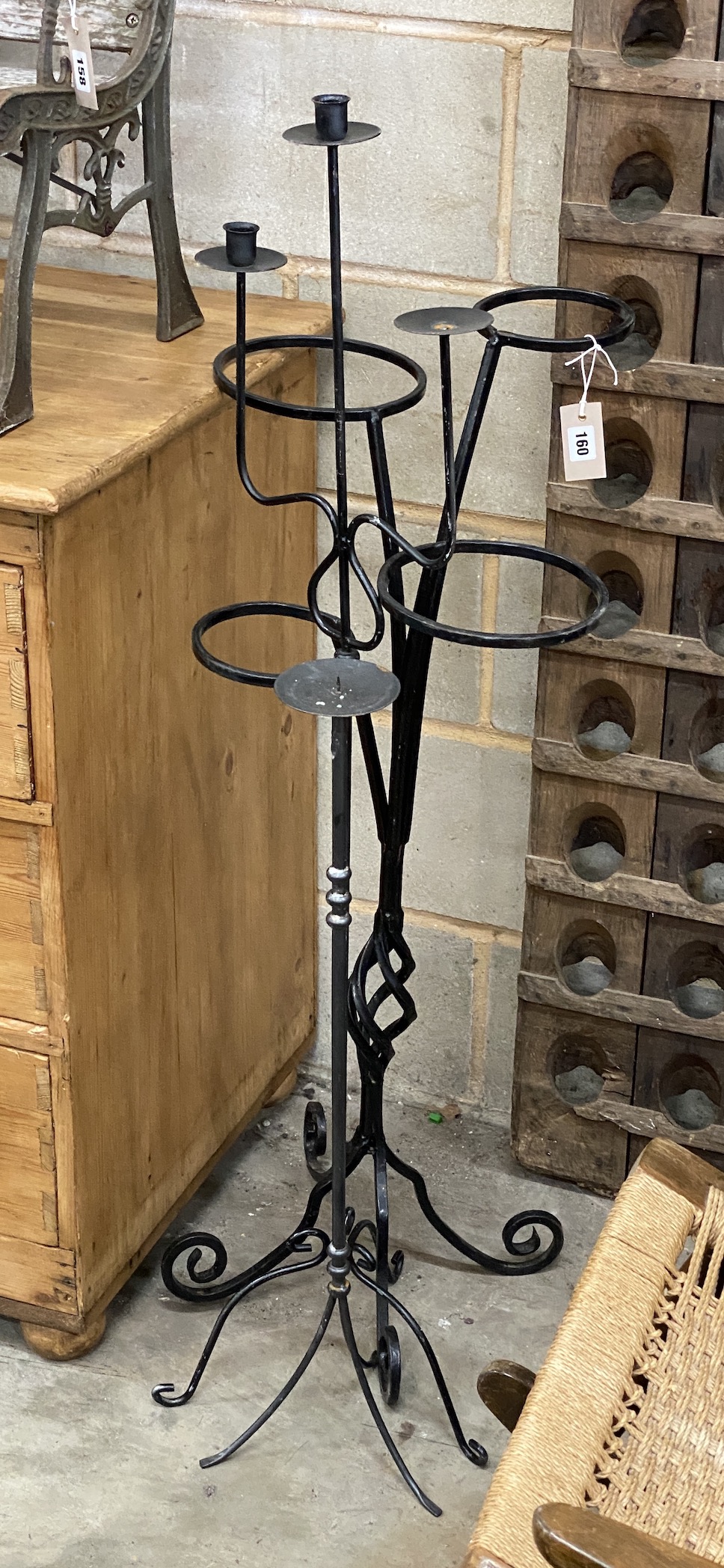 A wrought iron pot stand and two candle holders